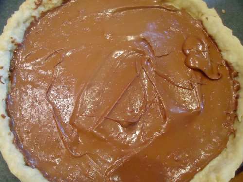 Pour the warm chocolate into the cooled crust. Use a spatula or back of a large spoon to smooth the chocolate layer. Refrigerate the tart at this point. It must be cool before adding the top rum cream layer. 