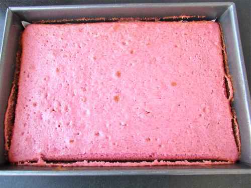 After baking, it is still pink! Allow to cool in the pan a bit, then remove to a rack and remove parchment paper. It should be completely cool before frosting!